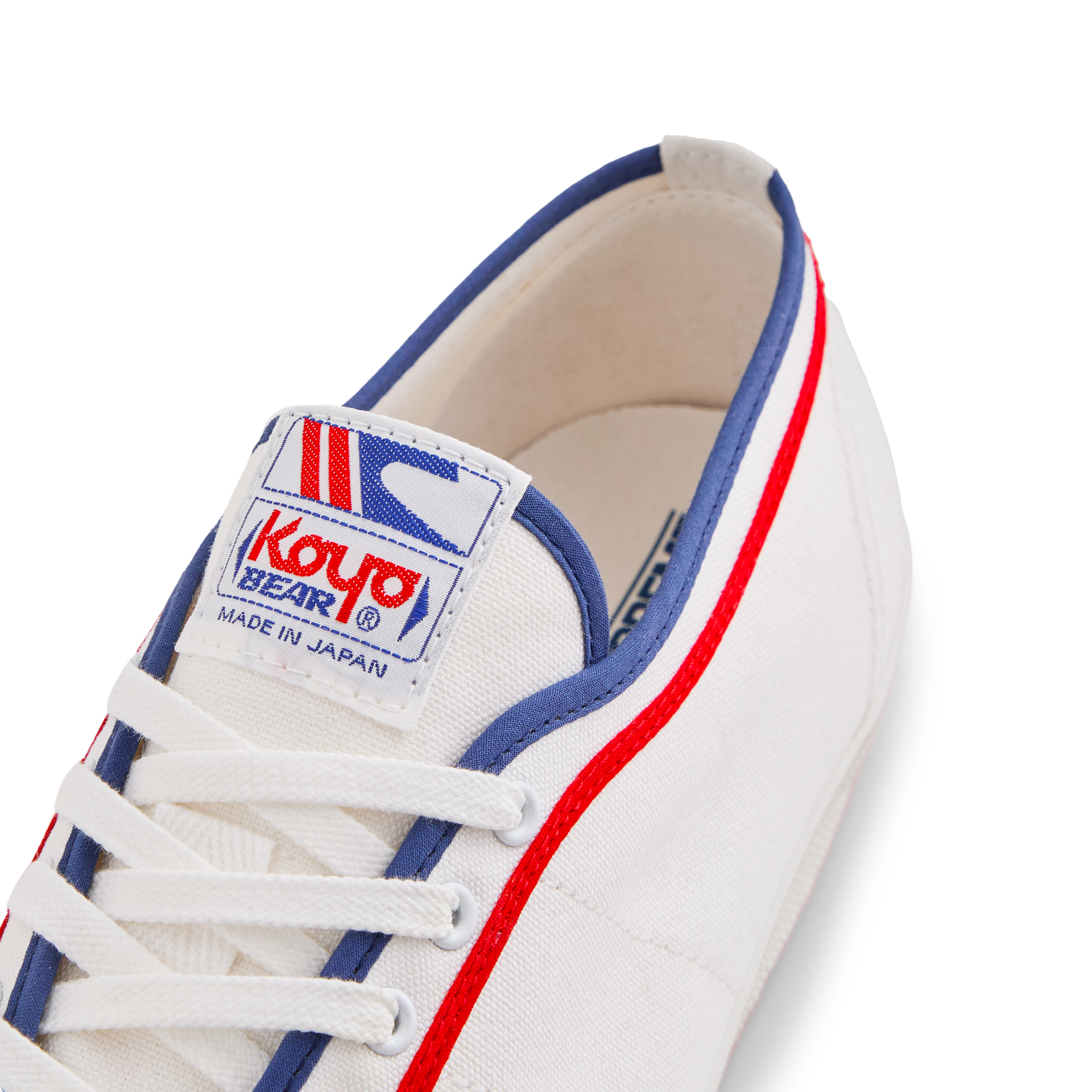 Tongue label of the white Koyo Bear Sharpman Marty Supreme sneakers with red and blue trim, showing the logo and Made in Japan branding.
