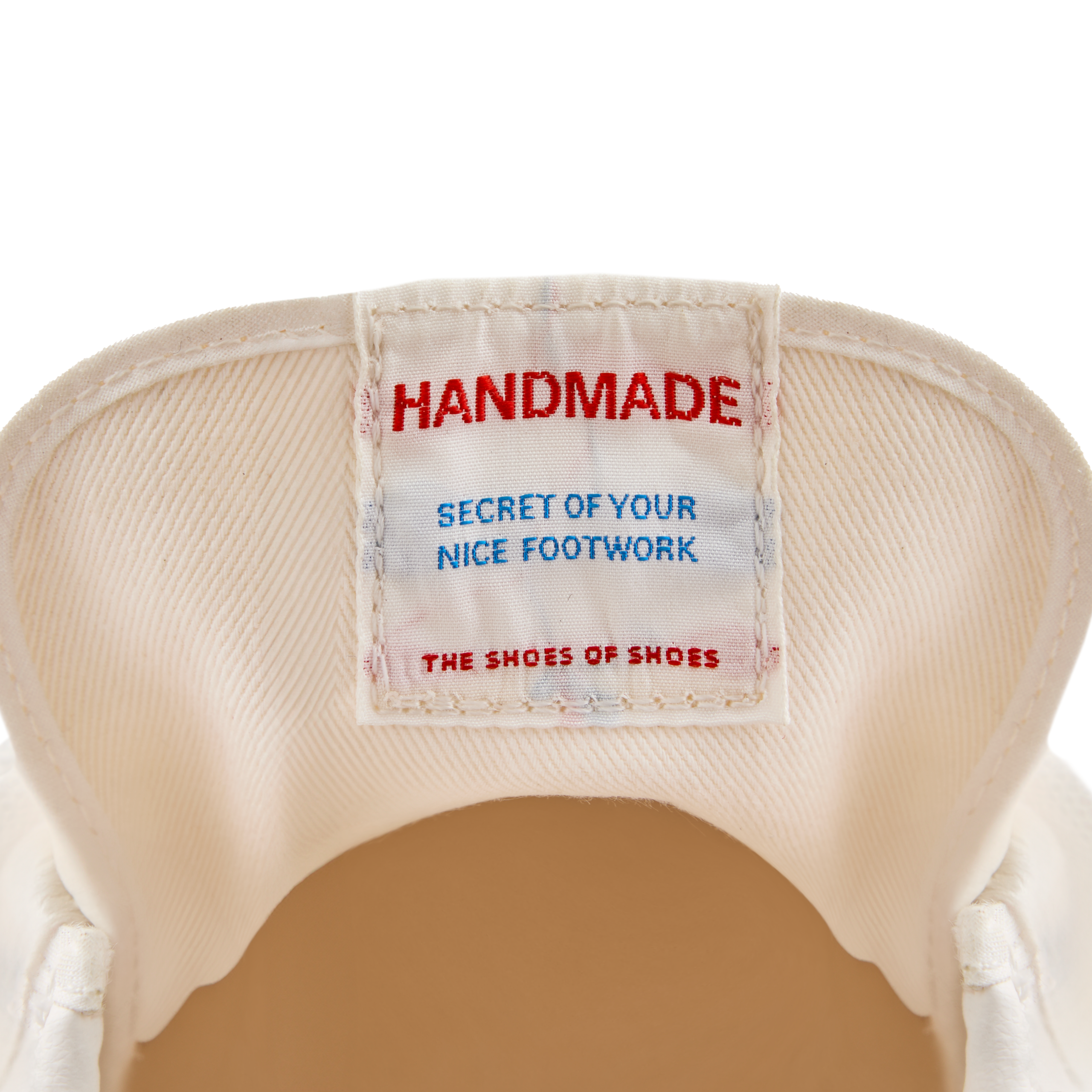 Close-up of the inner tongue label inside the Koyo Bear Sharpman Nimble sneakers reading ‘Handmade – Secret of Your Nice Footwork’, highlighting the Made in Japan craftsmanship.