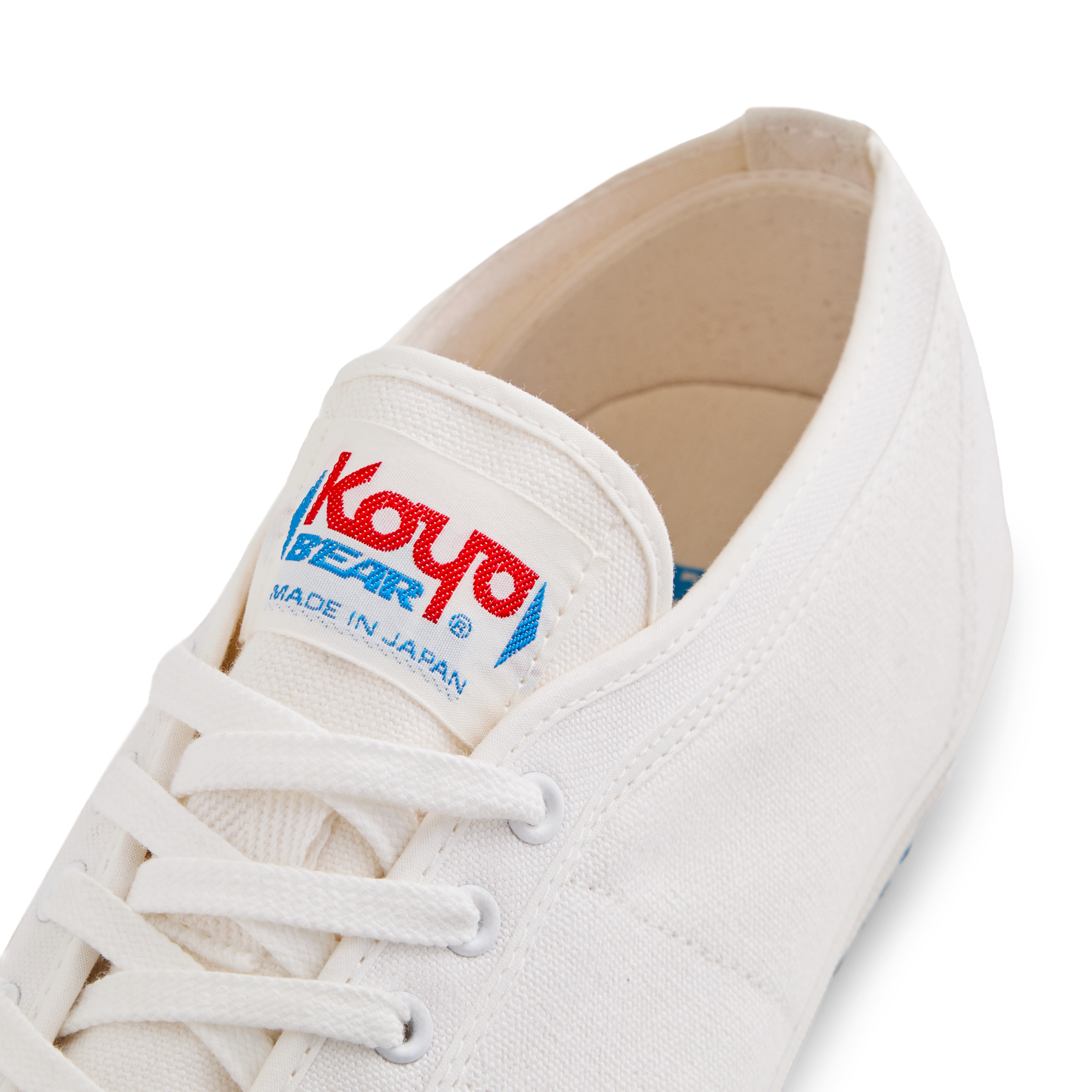 Close-up of the tongue label on the handmade Koyo Bear Sharpman White Trim canvas sneakers, made in Japan, showing the Koyo Bear logo on the world’s first purpose-built table tennis shoe.