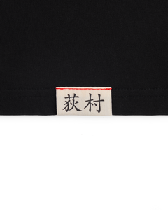 Close-up of the woven Ichiro Ogimura name label on the Koyo Bear OGI Signature Return T-shirt.