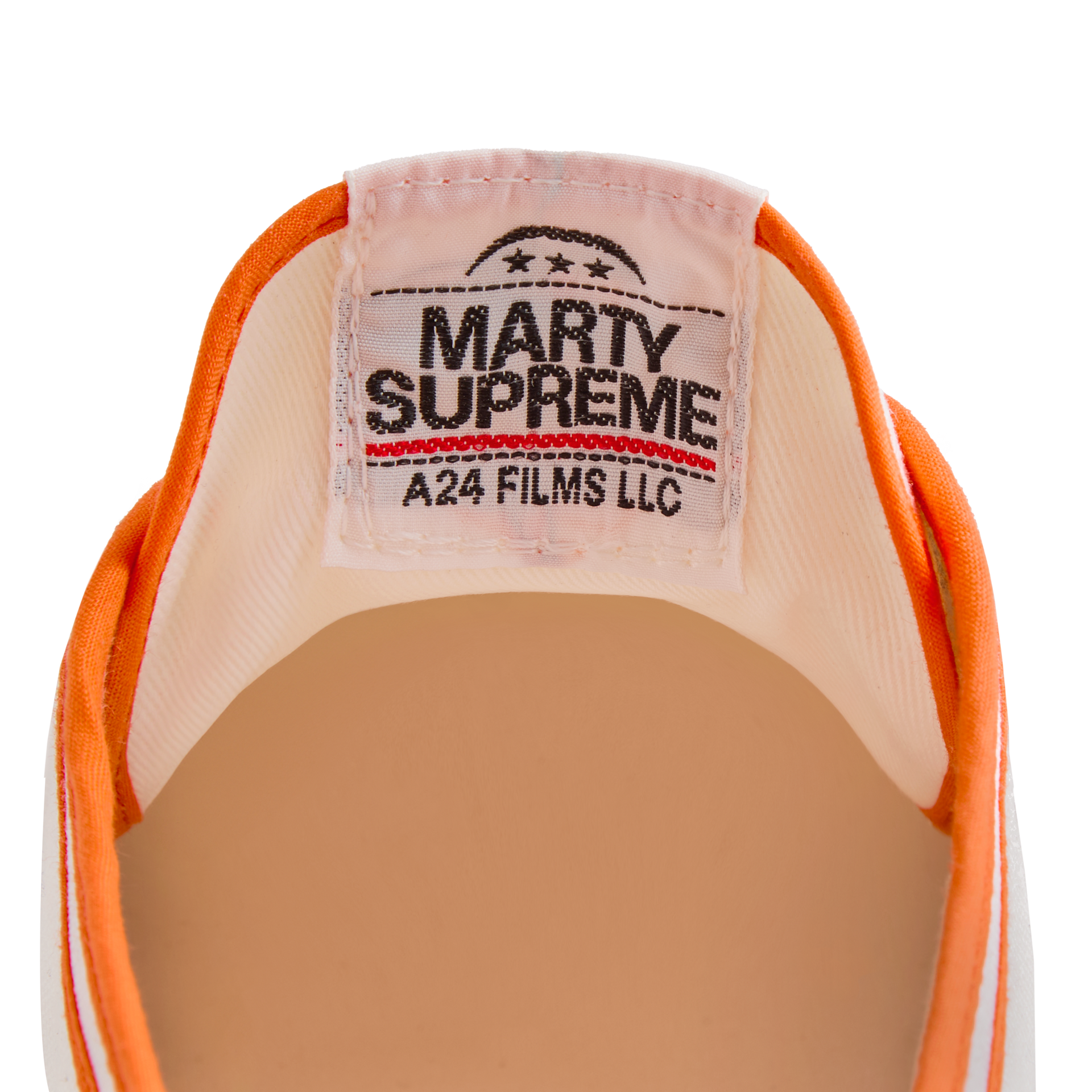 Close-up of the tongue label on the orange version Koyo Bear Sharpman Marty Supreme sneakers with red and blue trim, showing the A24 Films LLC logo and Made in Japan branding.