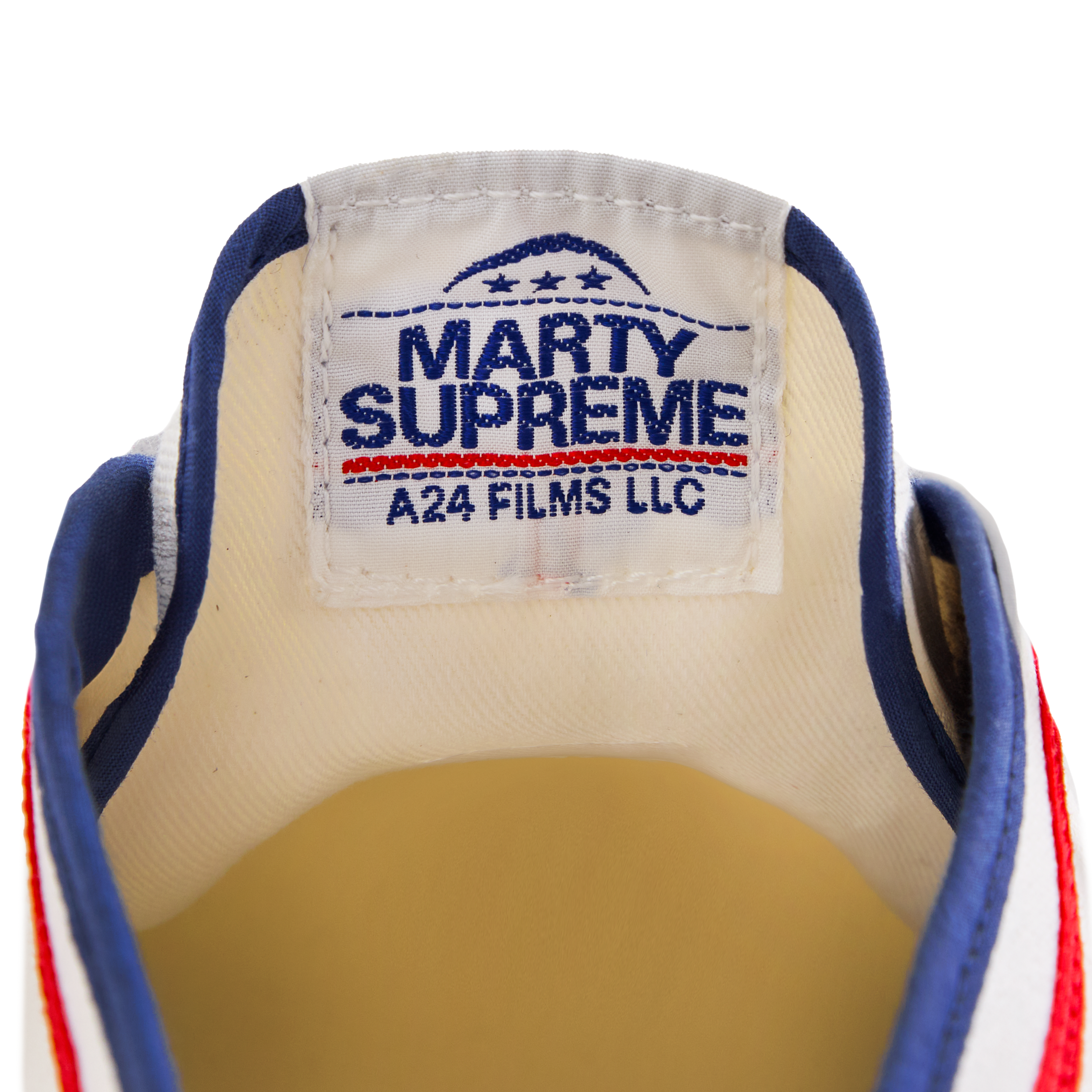 Close-up of the tongue label on the white Koyo Bear Sharpman Marty Supreme sneakers with red and blue trim, showing the A24 Films LLC logo and Made in Japan branding.