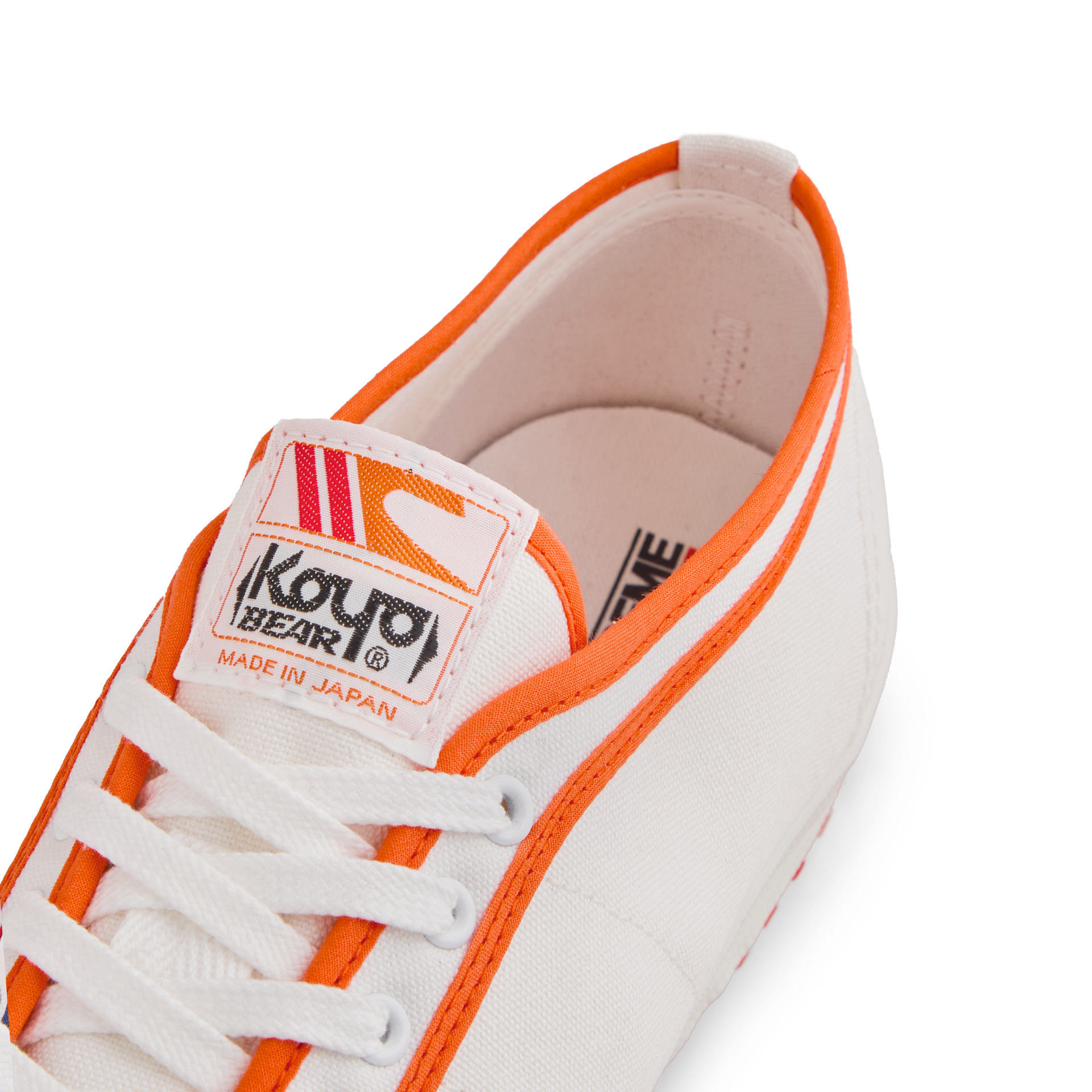Tongue label of the orange white Koyo Bear Sharpman Marty Supreme sneakers with red and blue trim, showing the logo and Made in Japan branding.