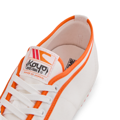 Tongue label of the orange white Koyo Bear Sharpman Marty Supreme sneakers with red and blue trim, showing the logo and Made in Japan branding.