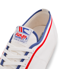 Tongue label of the white Koyo Bear Sharpman Marty Supreme sneakers with red and blue trim, showing the logo and Made in Japan branding.
