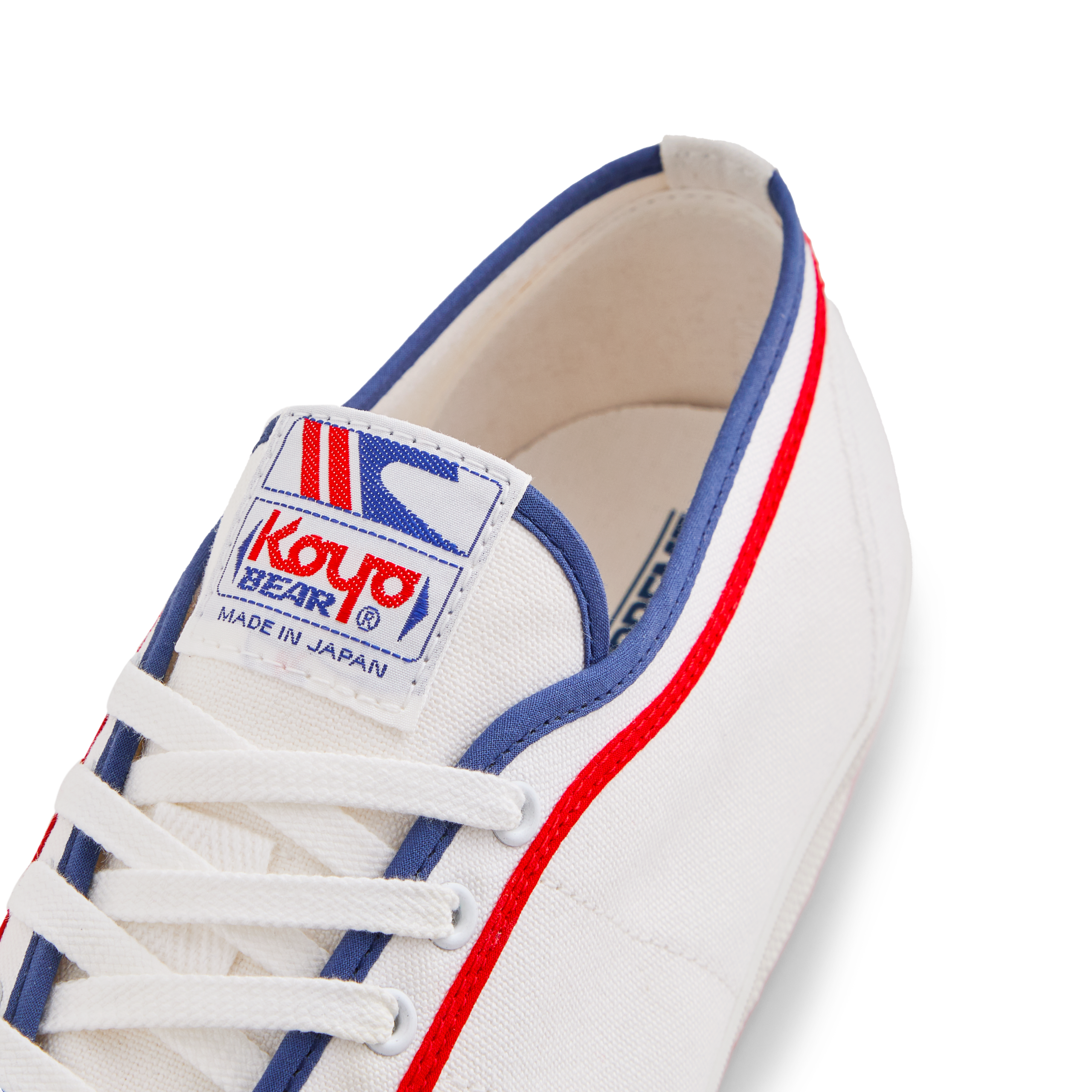 Tongue label of the white Koyo Bear Sharpman Marty Supreme sneakers with red and blue trim, showing the logo and Made in Japan branding.