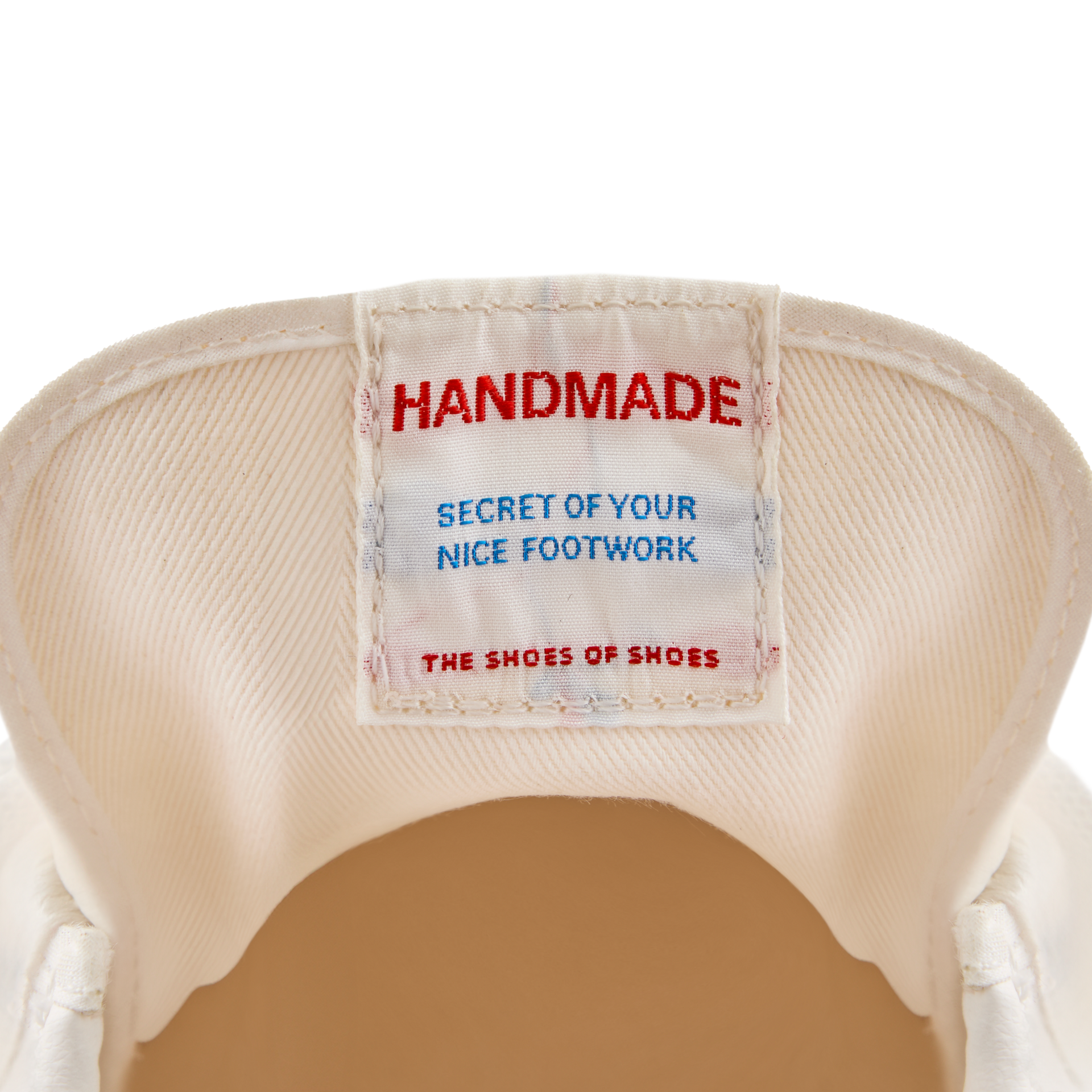 Close-up of the inner tongue label inside the Koyo Bear Sharpman Nimble red sneakers reading “Handmade – Secret of Your Nice Footwork”, highlighting the Made in Japan craftsmanship.
