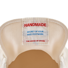 Close-up of the inner tongue label inside the Koyo Bear Sharpman Nimble red sneakers reading “Handmade – Secret of Your Nice Footwork”, highlighting the Made in Japan craftsmanship.