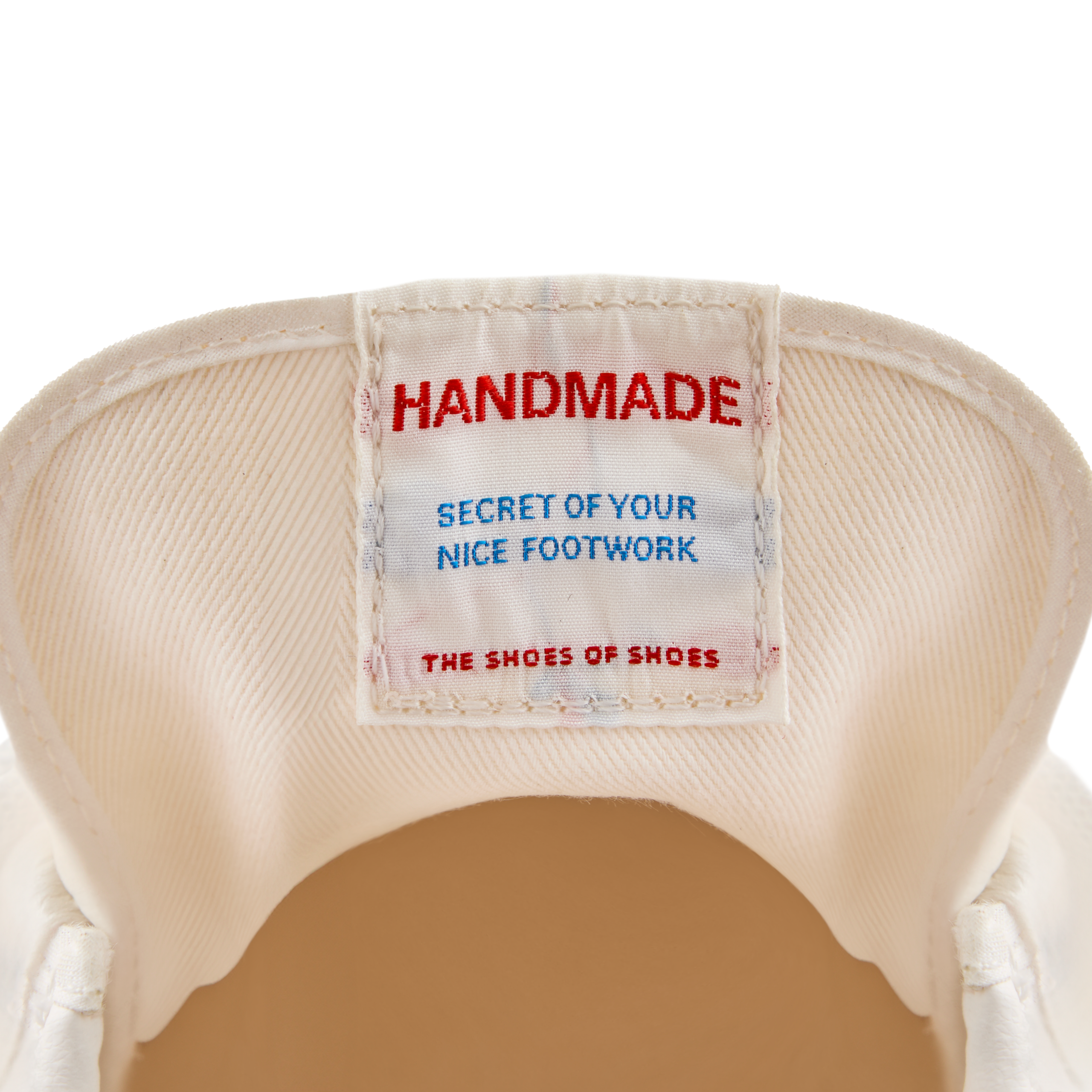 Close-up of the inner tongue label inside the Koyo Bear Sharpman Nimble red sneakers reading “Handmade – Secret of Your Nice Footwork”, highlighting the Made in Japan craftsmanship.