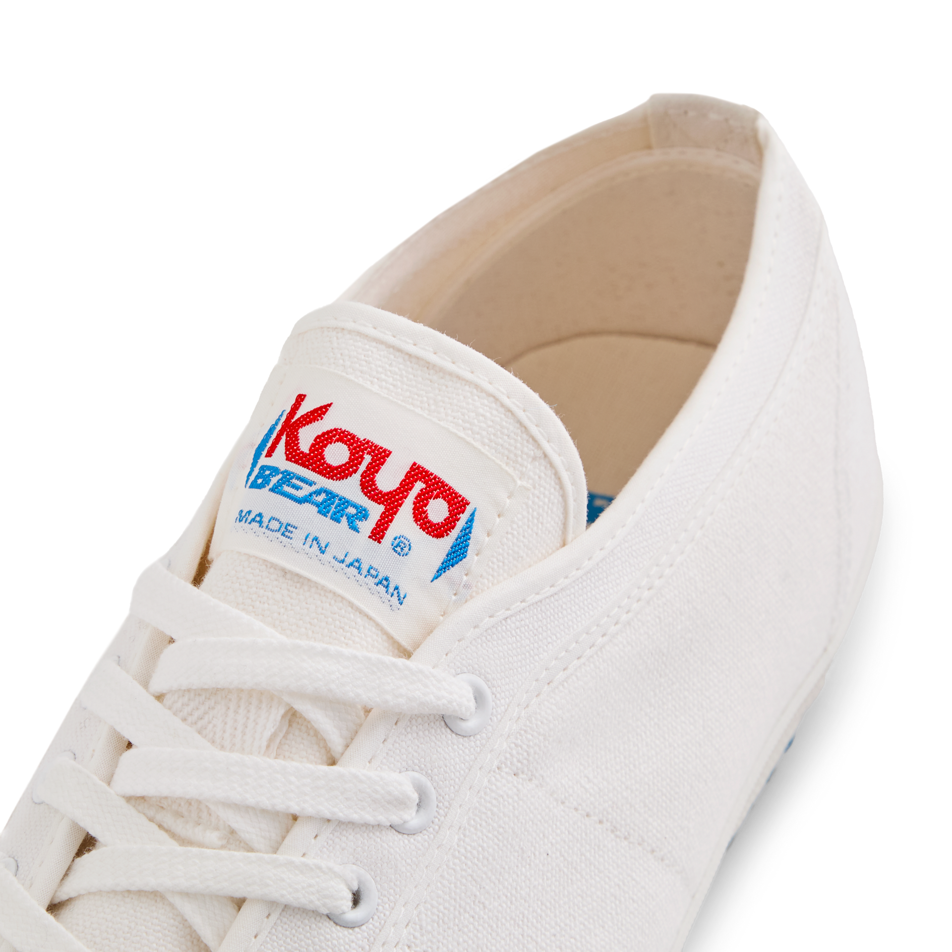 Close-up of the tongue label on the handmade Koyo Bear Sharpman White Trim canvas sneakers, made in Japan, showing the Koyo Bear logo on the world’s first purpose-built table tennis shoe.